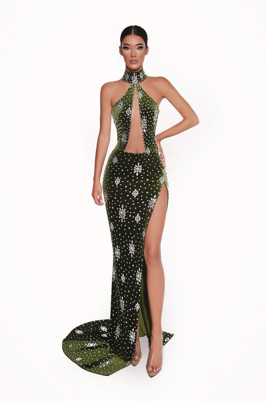 Woman wearing a green evening gown with floral patterns on a white background