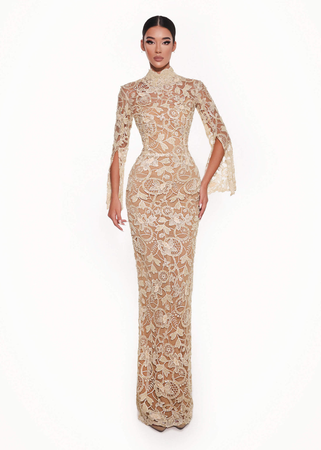 Woman wearing a beige lace evening gown on a white background