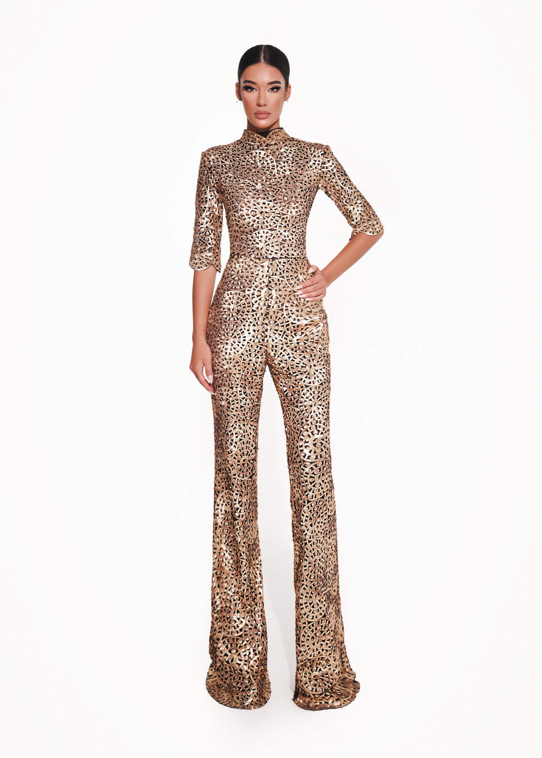 Gold sequin jumpsuit worn by a model on a white background