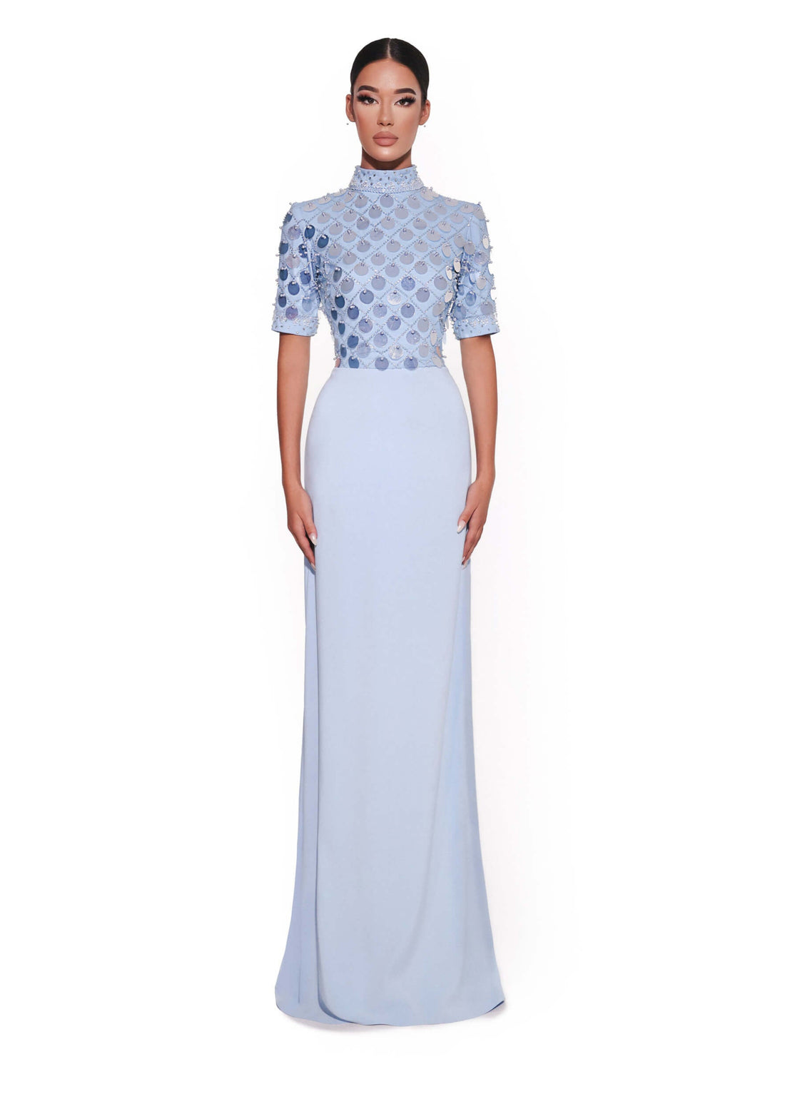 Woman wearing a light blue dress with a patterned top on a white background