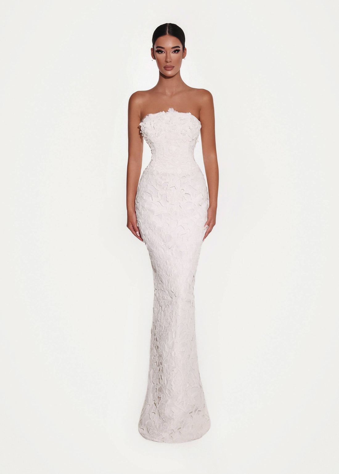 Woman wearing a strapless white wedding dress on a white background