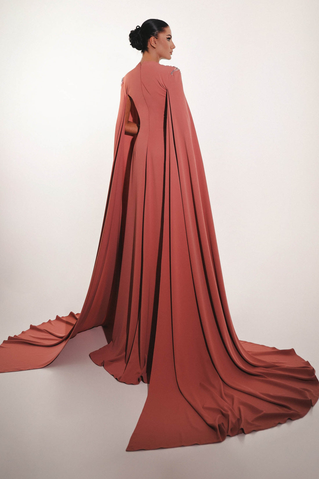 Side view of blush crepe couture gown with dramatic cape sleeves 