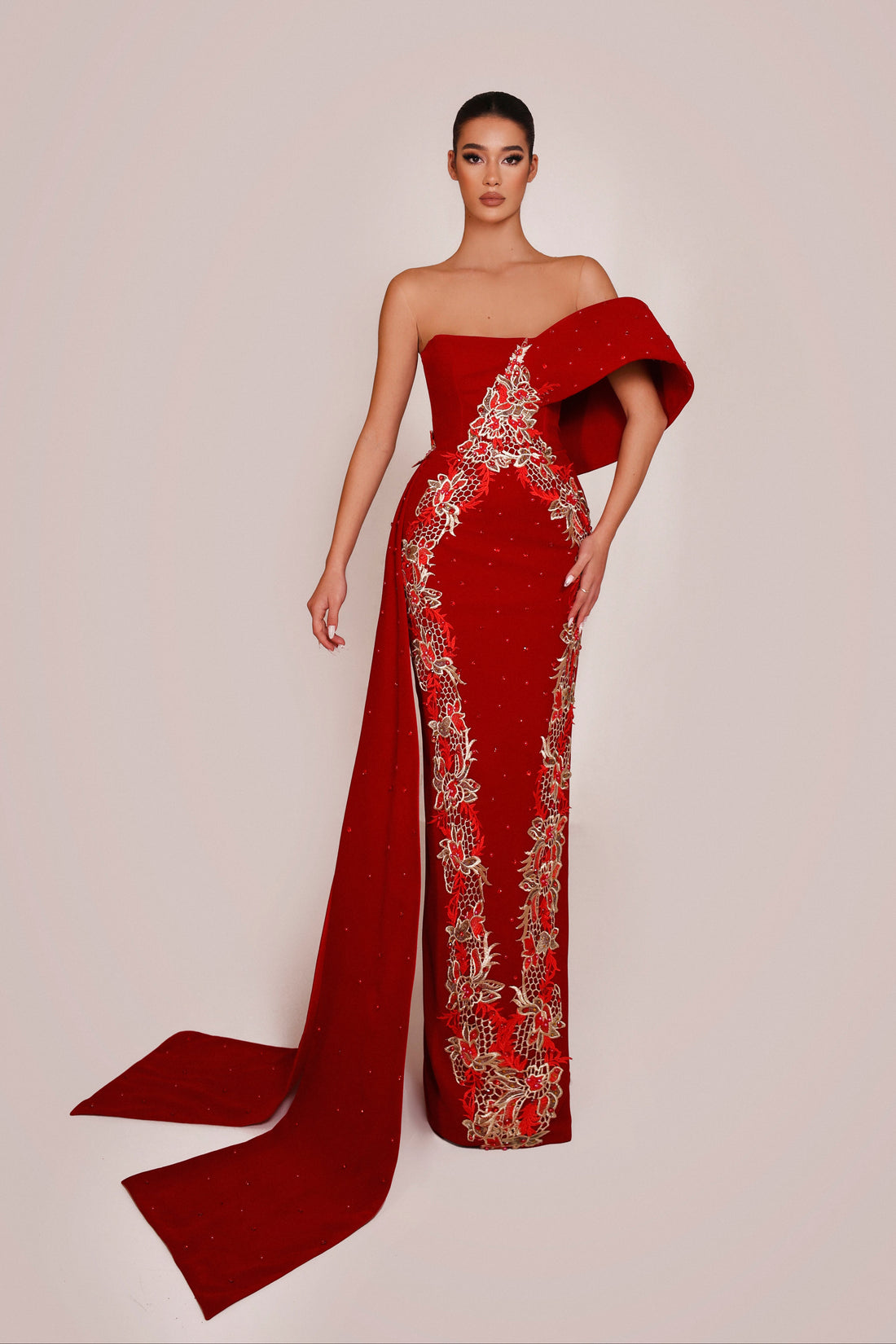 Red evening gown with intricate detailing on a plain background