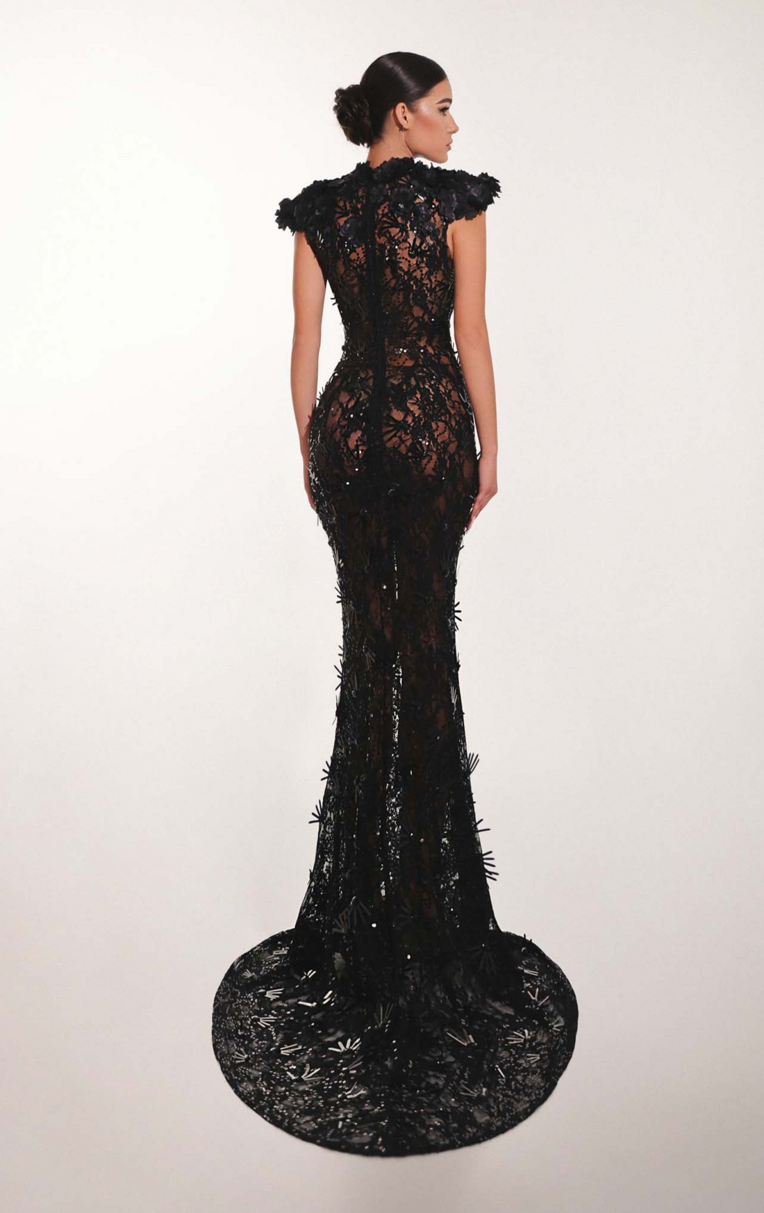 Black lace evening gown on a model against a white background