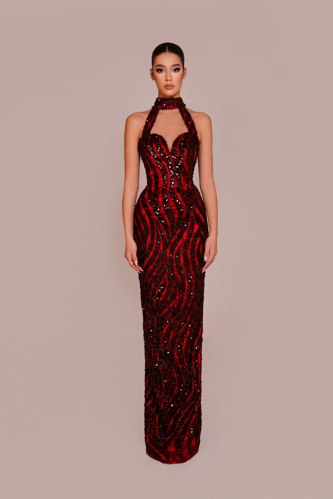Red sequin evening gown on a model against a beige background